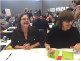 "Wallace Middle School SIM Coach Christy Henry partners with Barton Middle School principal Teri Eubank to play CLC trivia  at the Hays District Literacy Leadership Team meeting."